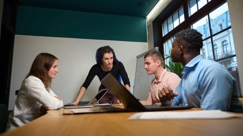 Bossy woman demanding creative ideas for new project from multiethnic team Bossy woman demanding creative ideas for new project from multiethnic team during meeting in cozy office, men and women brainstorming, discussing business strategies